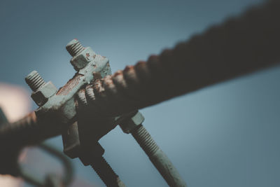 Low angle view of rusty metal against sky