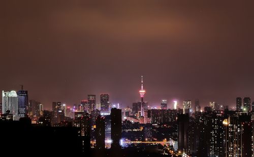 Illuminated buildings against sky at night