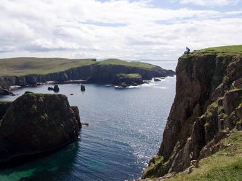 Scenic view of sea amidst cliff