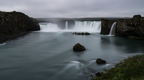 Scenic view of waterfall against sky