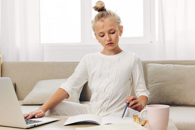 Young woman using laptop at home