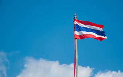 Low angle view of flag against blue sky