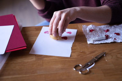High angle view of woman doing crafting loveletter on table 