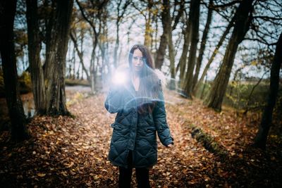 Portrait of woman with flashlight in forest