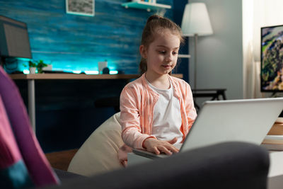 Girl looking at camera while sitting at home