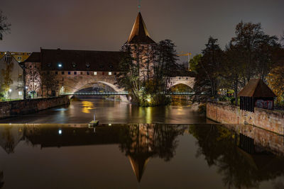 Bridge over river against sky at night