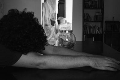 Rear view of a man drinking from glass at home
