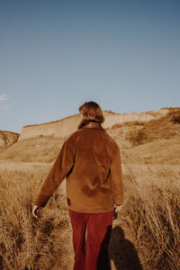 Rear view of woman standing on field