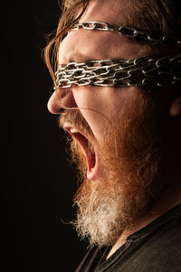 Close-up portrait of man over black background