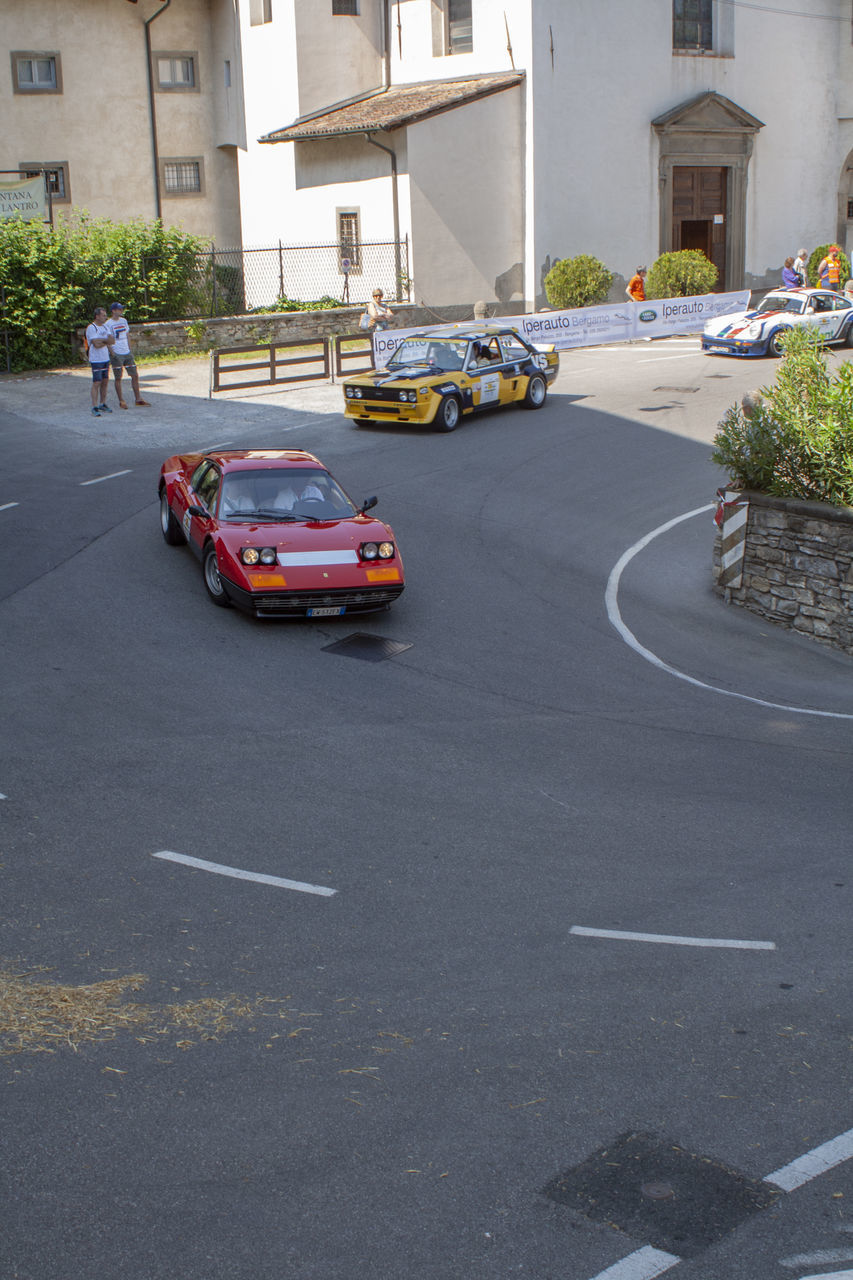 VEHICLES ON ROAD BY BUILDINGS