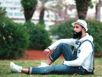 Full length of young man sitting at park