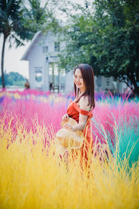 Portrait of young woman standing in park