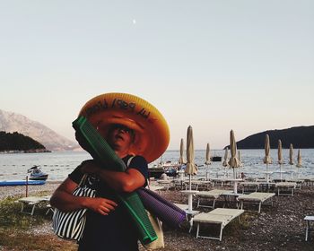 Man standing at beach against clear sky