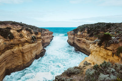 Rock formations by sea against sky