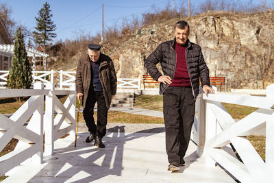 Full length of senior man standing on bridge in winter