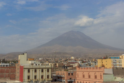 Buildings in city against cloudy sky