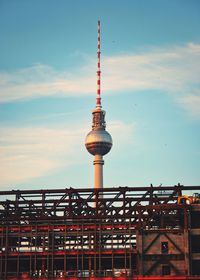 Low angle view of communications tower against sky in city