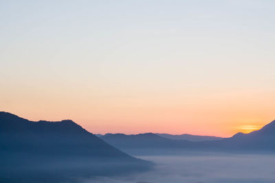 Scenic view of silhouette mountains against sky during sunset