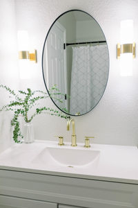 Modern white bathroom with round mirror 