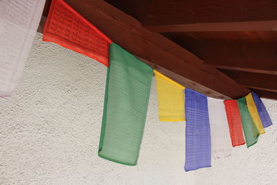 Low angle view of multi colored flags hanging against wall