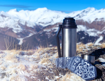 Close-up of snow covered land against mountains