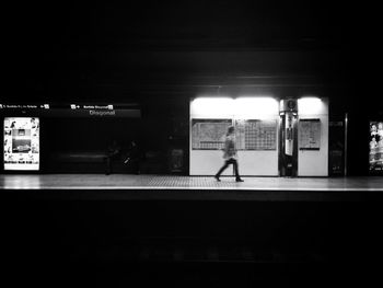 Silhouette people at railroad station at night