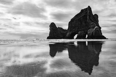 Scenic view of rock formations on sea against sky