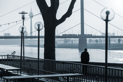 Rear view of man standing in front of river