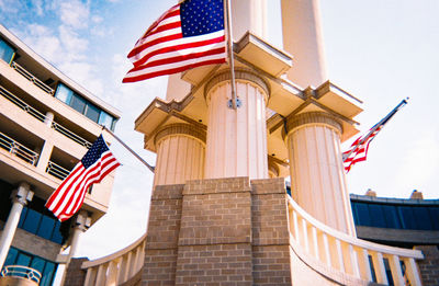 Low angle view of flags on building against sky