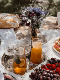 An aesthetic picture of brunch in the garden with two lemonades, flowers and fruit