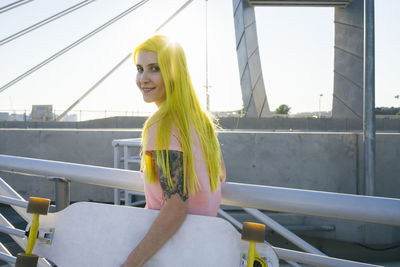 Portrait of woman smiling against railing