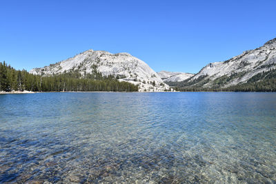 Scenic view of lake and mountains against clear blue sky