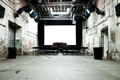 Empty chairs against projection screen in old auditorium