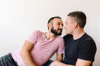 Gay couple kissing at home.