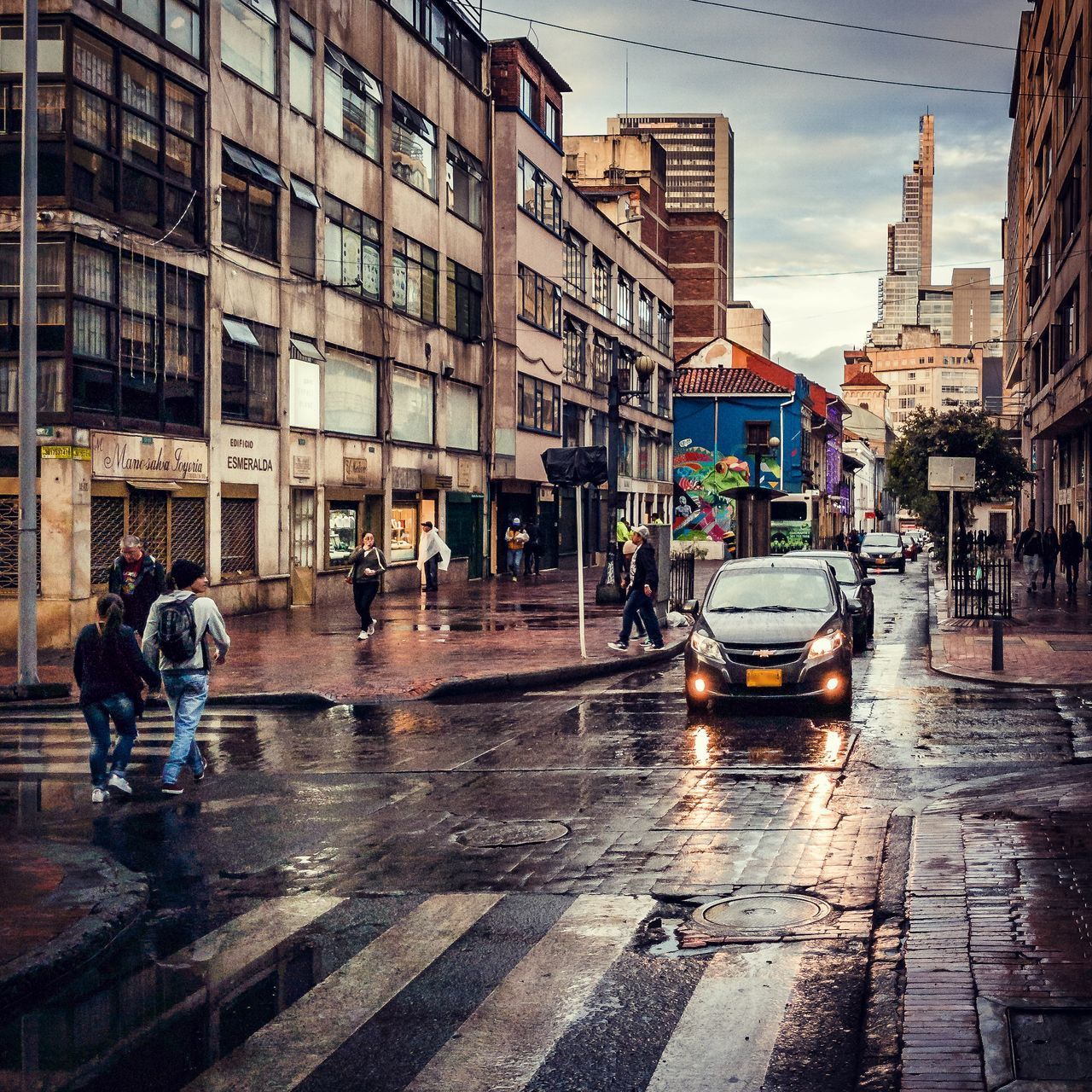 PEOPLE ON WET STREET AGAINST BUILDINGS