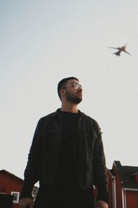 Low angle view of man standing against clear sky