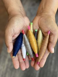 Close-up of hand holding colored pencils