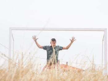 Portrait of goalie standing against clear sky