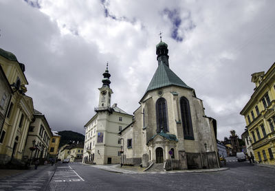 Low angle view of cathedral against cloudy sky in city