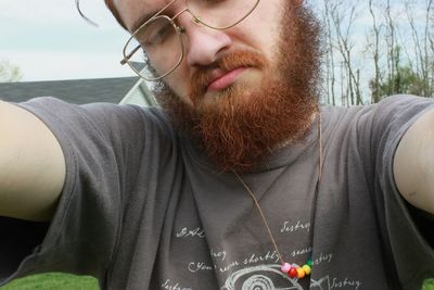 Close-up of man wearing sunglasses standing against sky