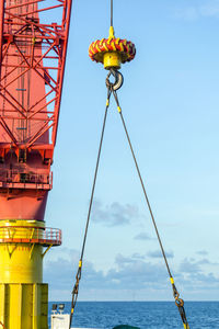 An offshore pedestal crane on board a construction work barge performing a lifting of an anchor 