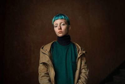 Portrait of woman standing against wall