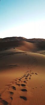 Sand dunes in desert against clear sky