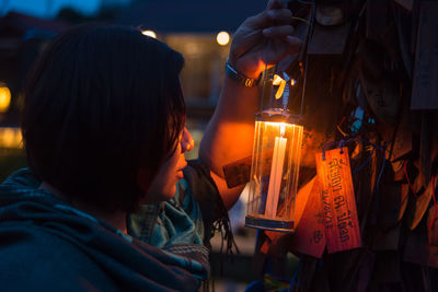 Rear view of woman holding lit candles