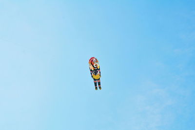 Low angle view of kite flying against clear blue sky