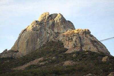 Low angle view of rock formation on mountain against sky