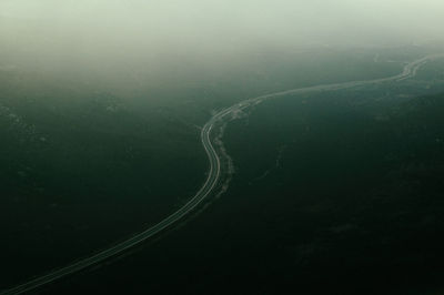 Aerial view of road amidst landscape during foggy weather