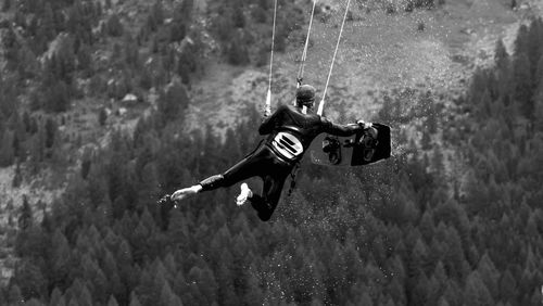 Midsection of kite surfer holding on to his board