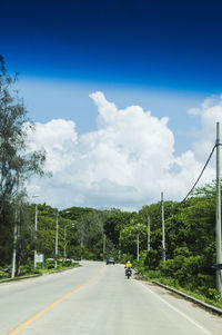 Road amidst trees against sky