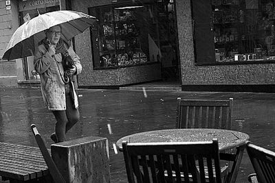 Woman with umbrella walking on wet rainy day in city